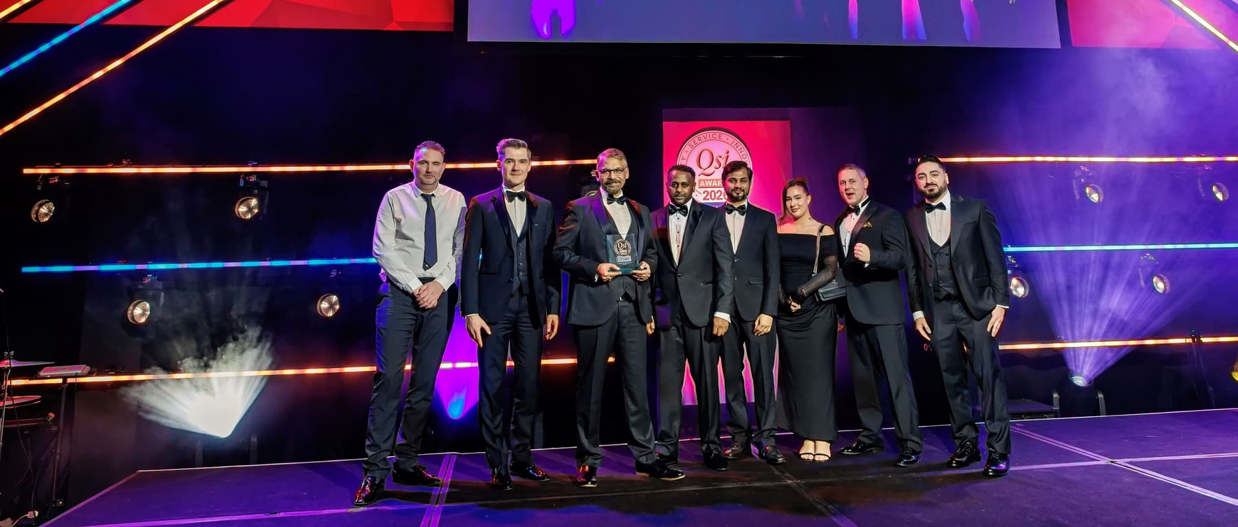 Odysse team members on stage at the 2026 Professional Driver QSi Awards, holding their award